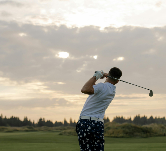  Male golfer in mid-swing on a golf course at sunset, symbolizing elite athletic performance and global ambition – banner image for Hogan Lovells and GSE Worldwide case study
