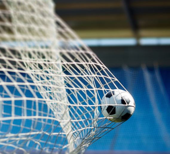  Soccer ball hitting the back of the net in a stadium, symbolizing a major acquisition. Global law firm Hogan Lovells advised Presidio on securing full ownership of Hellas Verona Football Club, marking a milestone in cross-border sports investment