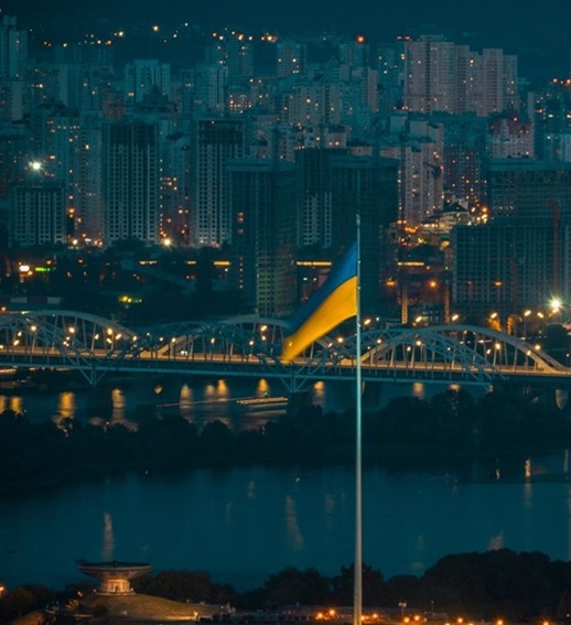  Kyiv skyline at night with the Ukrainian flag and the Motherland Monument overlooking the Dnipro River, symbolizing Hogan Lovells’ landmark High Court victory for PrivatBank in its $2 billion fraud case.