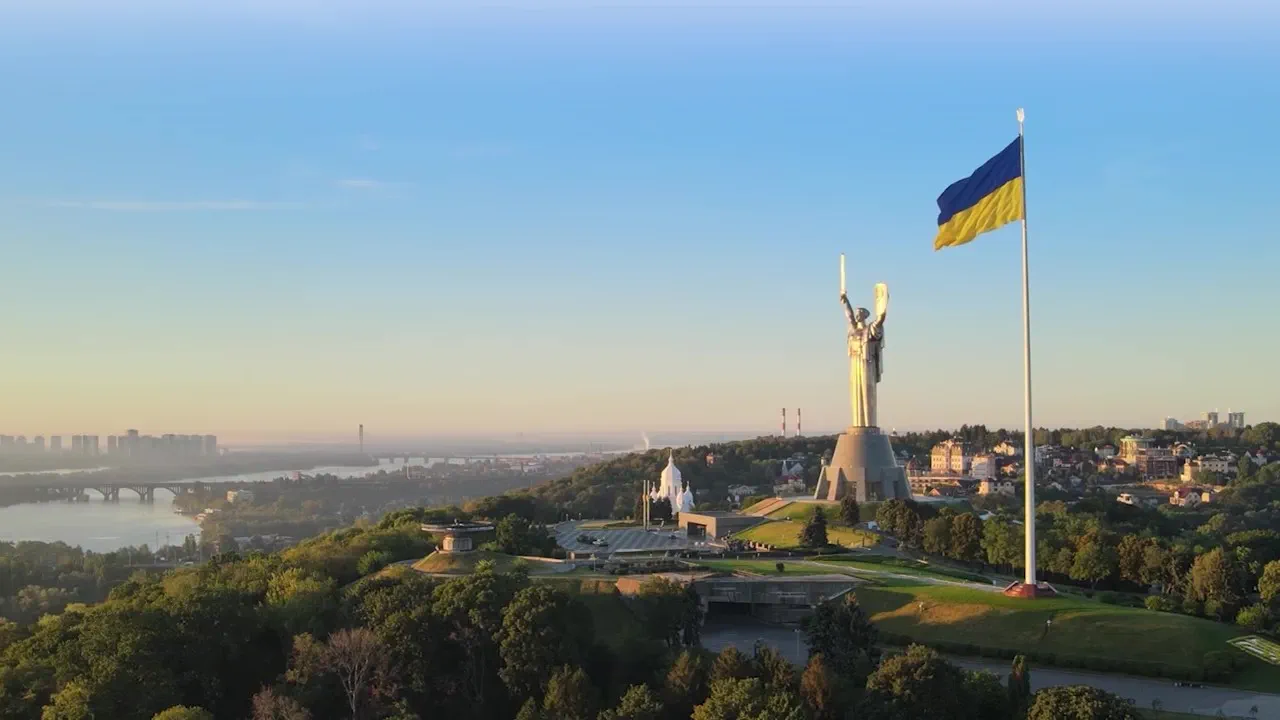Kyiv skyline at sunrise featuring the Motherland Monument and Ukrainian flag, referencing the Hogan Lovells PrivatBank legal case study page